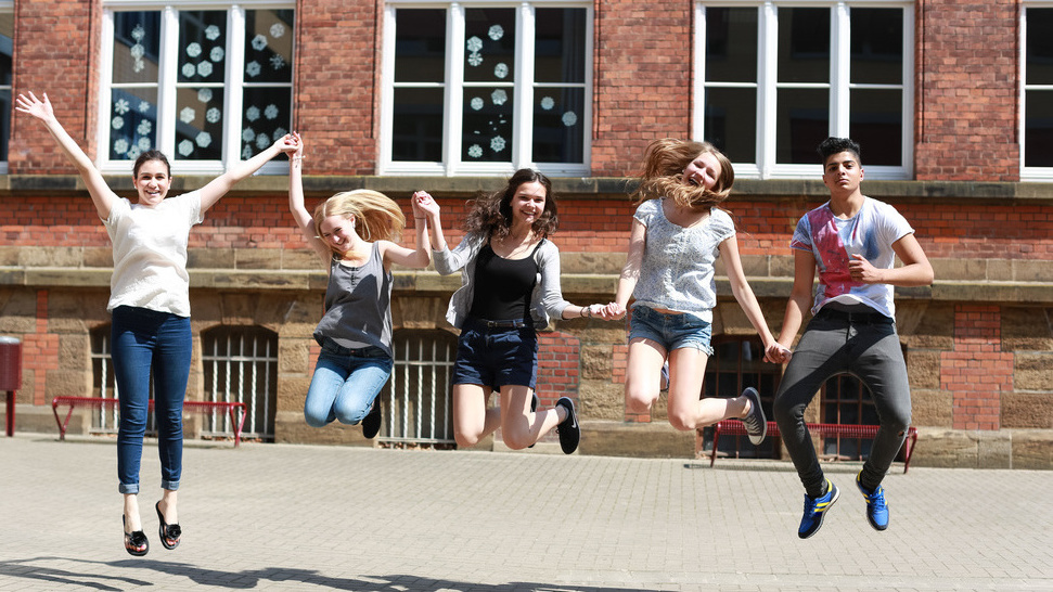 Fröhliche Schüler springen in die Luft
