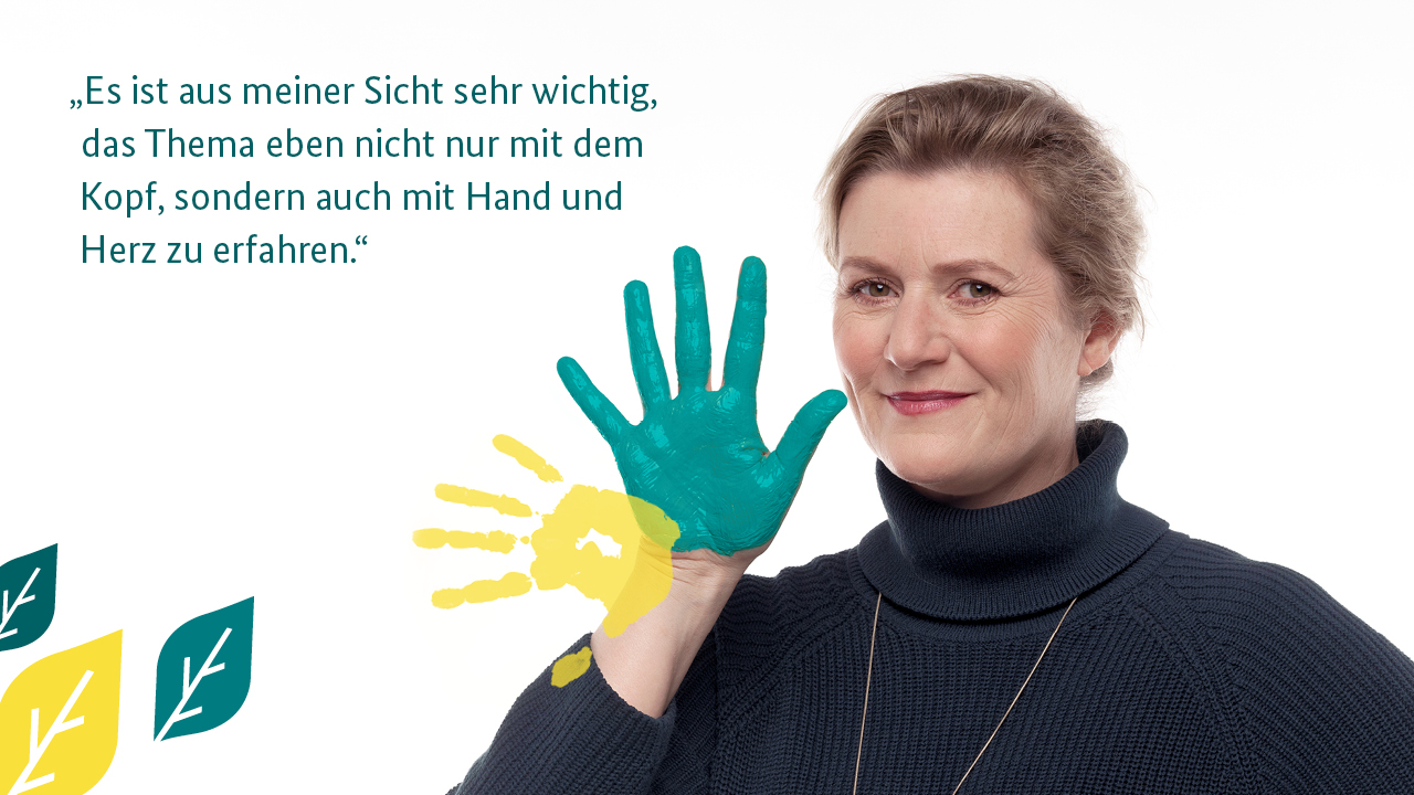 Anja Rosswinkel im dunkelblauen Rollkragenpullover hält ihre grün bemalte Hand in die Kamera, daneben ein Zitat von ihr: "Es ist aus meiner Sicht sehr wichtig, das Thema eben nicht nur mit dem Kopf, sondern auch mit Hand und Herz zu erfahren."