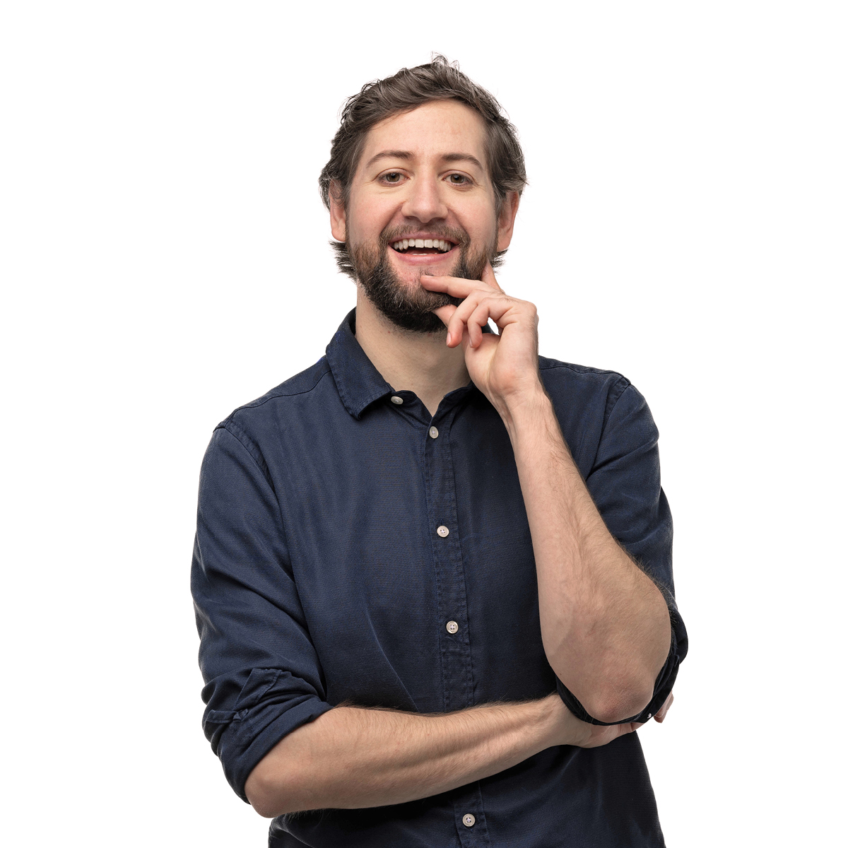Robin Blase steht in die Kamera lächelnd vor einem weißen Hintergrund, eine Hand am Kinn, die andere vor der Brust verschränkt.